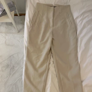 Beige kostymbyxor - Snygga beige kostymbyxor med hög midja och raka ben. Endast testade. Väldigt stilrena och fungerar formellt och till vardags 🤍 Köpta från Zara för runt 600kr Tveka inte att skriva om du vill ha fler bilder eller har frågor 🤍🥰 