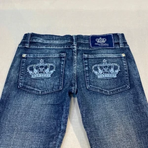 Victoria Beckham Jeans - Super snygga jeans med detaljer på bakfickorna. De är bootcut-stil och lågmidjade, vilket ger en avslappnad och trendig look. Perfekta för dig som vill ha något extra i garderoben. Är i storlek w28. Obs läs vad som står i min profil.💗