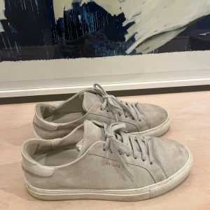 Beigea sneakers från Axel Arigato - Snygga beige sneakers från Axel Arigato i mocka med snörning. Använts 2 gånger, men är i väldigt bra skick! Originalpris 2200kr
