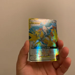 Pokémonkort Moltres & Zapdos & Articuno GX - Säljer ett holografiskt Pokémonkort med Moltres, Zapdos och Articuno GX. Kortet har 300 HP och inkluderar attacker som Trinity Burn och Sky Legends GX. Det är en del av TAG TEAM-serien och har nummer 66/68.