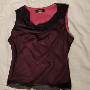 Gullig svart/rosa topp - Söt ärmlös topp i svart och rosa. Toppen har en elegant draperad halslinje och är ärmlös!💕