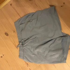 Blå shorts med snörning - Säljer ett par blå  shorts med snörning i midjan. De har en avslappnad passform och är perfekta för en bekväm stil. Shortsen är tillverkade i ett mjukt material som känns skönt mot huden.