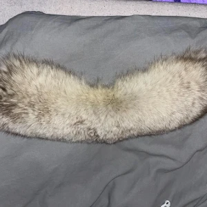 Beige pälsliknande halsduk - Säljer en lyxig och mjuk beige pälskrage. Den har en glansig insida och är perfekt för att hålla dig varm under kyliga dagar. Passar utmärkt för att ge en elegant touch till din outfit. Cirka 50cm lång, 15cm bred. 