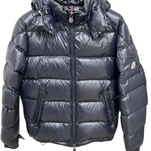 Moncler maya  - Snygg svart pufferjacka från Moncler med huva och dragkedja. Jackan har ett quiltat mönster och två praktiska fickor framtill. Perfekt för kyliga dagar när du vill hålla stilen. Mvh scandicfashion 