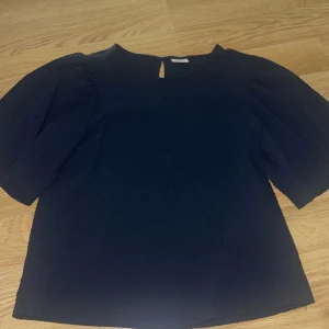 Mörkblå topp från JDY - Säljer en mörkblå blus från JDY med en knapp i nacken. Super skönt material. Pösigt i ärmarna 🥰