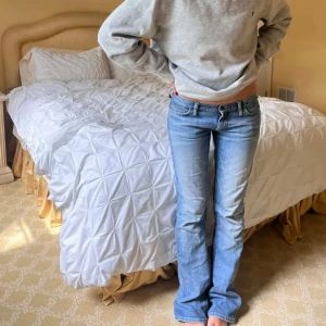 Blå bootcut jeans lowwaist  - Snygga blå bootcut jeans med låg midja. Perfekta för en avslappnad stil. Klassisk design med fem fickor och knappgylf.