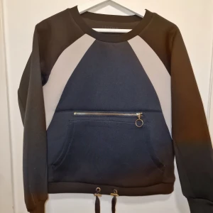 Svart och blå sweatshirt med dragkedja - Snygg och bekväm sweatshirt i scuba material. Perfekt för en unik look. Garderobsrensning så kika gärna på övriga auktioner.