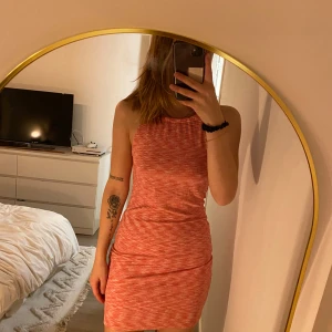 Röd kortklänning från Pieces - Säljer en snygg rosa kortklänning från Pieces. Klänningen är ärmlös och har en tight passform, perfekt för sommarens varma dagar. Den har ett subtilt mönster som ger en extra touch till looken. Perfekt för att känna sig både bekväm och stilren.