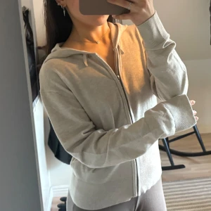 Beige stickad hoodie med dragkedja - Säljer en beige stickad hoodie med dragkedja och huva. Tröjan har långa ärmar och ribbade muddar vid ärmslut och nederkant.❤️