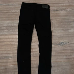 Svarta slim jeans från Jack & Jones - Snygga svarta slim jeans från Jack & Jones, modell Slim/Glenn. Perfekta för en stilren look med klassisk design och bekväm passform. Passar till många olika outfits.