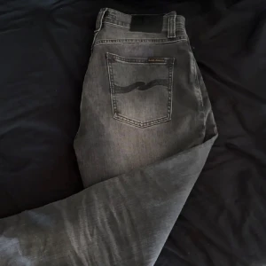Nudie Jeans Grim Trim  - Snygga grå jeans från Nudie med modellen Grim Trim. Jeansen är i väldigt gott skick och har inga defekter eller skador. Säljer dessa för endast 499kr ( ny pris 1200-1600kr) Hör av er vid frågor och funderingar!