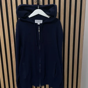 Kashmir zip - Snygg mörkblå kashmir zip från Ahlquist Clothing med dragkedja och huva. Perfekt för kyliga dagar. Den har långa ärmar och praktiska fickor framtill. Tröjan är nästintill oanvänd och är i super bra skick, något nopprig men borde gå att få bort!🤩