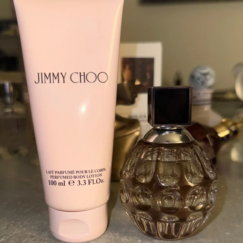 Elegant parfymflaska med en sfärisk design och en svart fyrkantig kork. Tillsammans med en matchande body lotion i en ljusrosa tub på 100 ml. Perfekt för den som vill dofta lyxigt och sofistikerat. Ca 58 ml kvar av 60. Lotionen ej använt. . Perfume.
