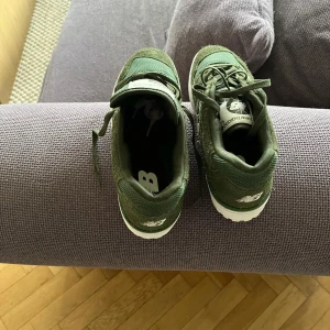 Gröna sneakers från New Balance - Snygga gröna New Balance 550 sneakers med snörning. Skorna har en stilren design med vit sula och märkets logga på sidan. Perfekta för en casual look.