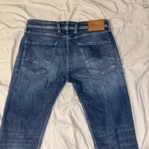 Blå jeans från Replay - Snygga blå jeans från Replay i ekologisk bomull. Klassisk femficksdesign med dragkedja och knapp. Perfekta för en avslappnad stil. Kontakta vid frågor.