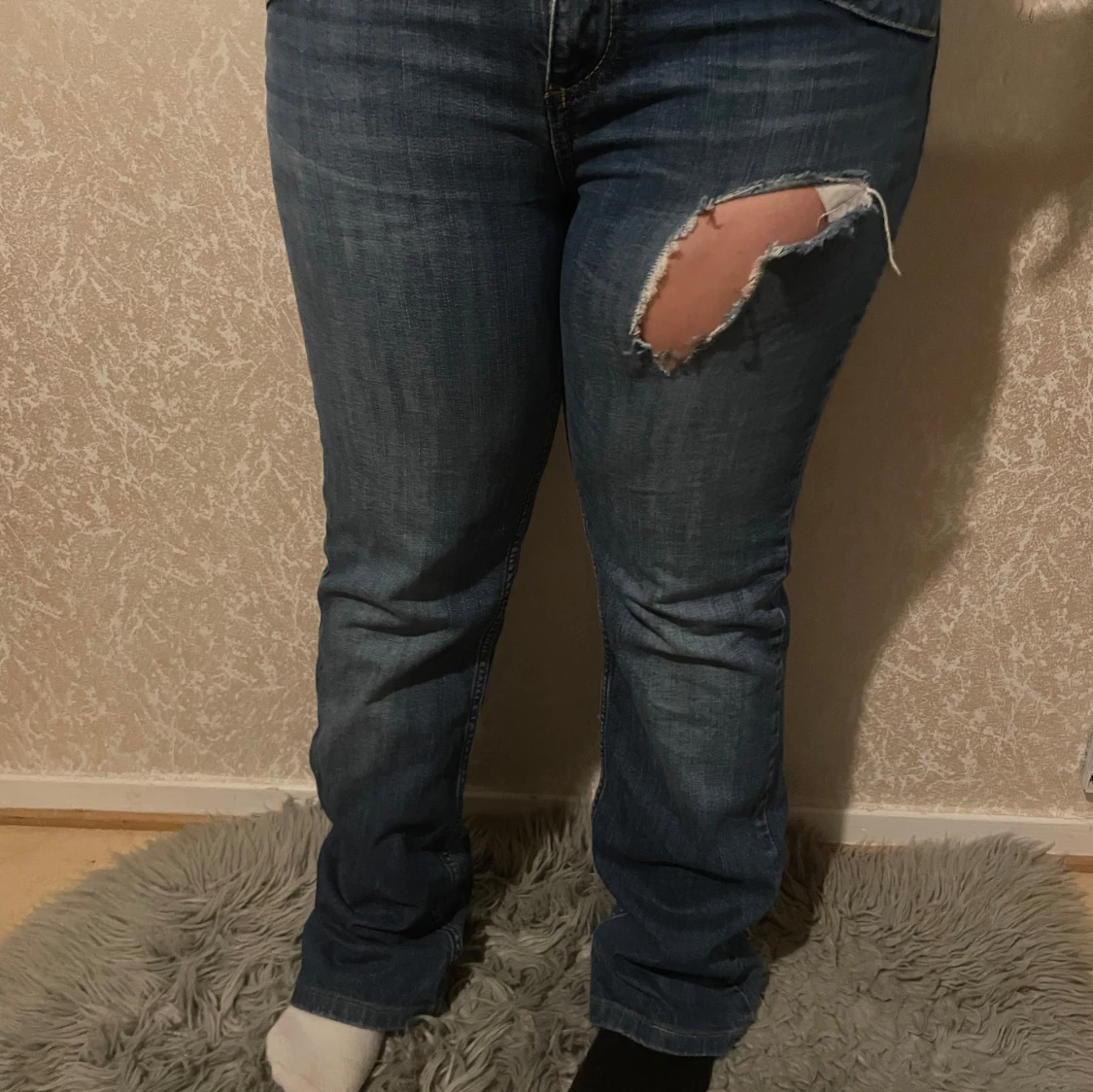 Blå jeans med slitning