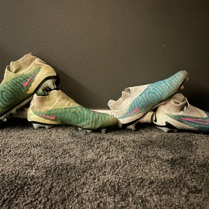 Nike phantom fotbollskor - Konstgräs skor och gräskor med spikdobbar i väldigt bra skick! Lite färgade av gräs på spikskorna men de mesta går att tvätta bort!