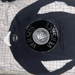 Svart tröja från Versus Versace - Säljer min svarta Versace paljett tröja då jag inte har nån användning för den. Den är knappt använd. Storlek s (passar  M)