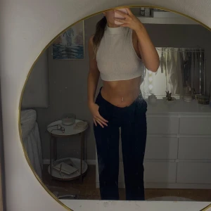 Vit ribbad croppad polotopp - Säljer en superfin vit ribbad polotopp som är croppad och perfekt för sommaren. Den är ärmlös och har en tight passform som framhäver figuren. Toppen är både stilren och bekväm.🧸🤎🪐