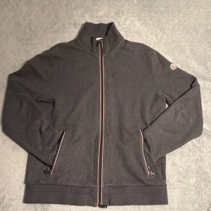 Moncler zip  - Moncler zip i storlek xl passar L Skick:8/10 finns en litet slitage vid armen och litet pinhole på baksidan Annars i fint skick!  Vid frågor eller funderingar skicka ett pm! 