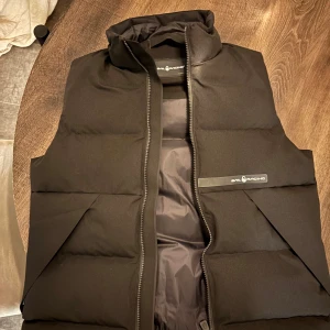 Svart sail racing väst  - Säljer en snygg svart väst från  sail racing har använt 2 gånger sen har den bara hängt i garderoben  det är en x smal