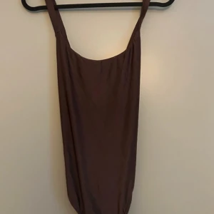 Brun body  - Säljer en stilren brun body med justerbara axelband. Den är ärmlös och har en enkel design som passar perfekt för både vardag och fest🤎