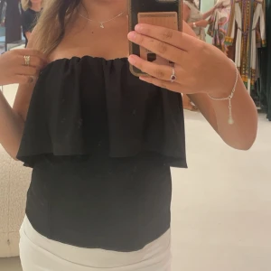 Svart axelbandslös topp - Säljer den populära volang tub toppen från zara. Endast använd några gånger