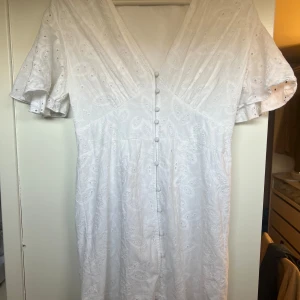 Studentklänning  - Superfin vit klänning med v-ringning och knappar framtill. Med korta ärmar med volangdetaljer, hade den under utspringande och älskade den💗💗💗