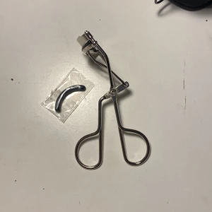 Ögonfransböjare  - Säljer en klassisk ögonfransböjare i metall med ett extra gummiband. Perfekt för att få till den där snygga böjen på fransarna. Enkel att använda och ger ett långvarigt resultat. Passar alla franslängder och är ett måste i sminkväskan!