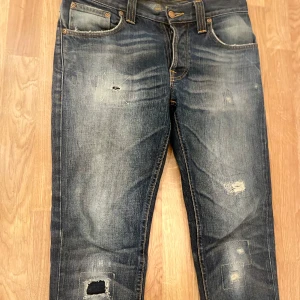 Nudie jeans - Tja, säljer nu dessa överfeta nudie jeansen i en slim passform. Storlek W29 L32. As fet tvätt och slitningar. Bra skick (8/10) bortsett från en defekt i ena fickan. Skriv vid minsta lilla fundering! Priset är ej hugget i stenen.