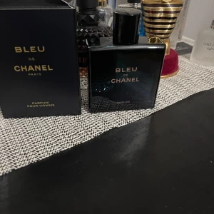 Bleu de Chanel Parfum Pour Homme - Säljer en elegant och tidlös Bleu de Chanel Parfum Pour Homme. Flaskan är stilren och mörkblå med en svart kork, vilket ger en lyxig känsla. Perfekt för den moderna mannen som vill ha en sofistikerad doft. Kommer i originalförpackning.