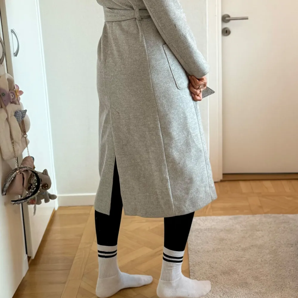 Säljer en elegant grå kappa från Morris Lady i storlek 36. Den är tillverkad av 100% ull och har en stilren design med knappar framtill och en slits bak. Perfekt för höst och vinter, och ger en klassisk look till vilken outfit som helst.. Jackor.