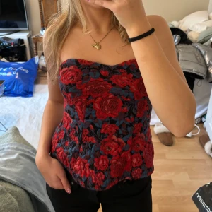 Blommig tubtopp - Säljer en superfin blommig tubtopp i rött och svart. Toppen är helt ny med prislapp kvar, endast testad! Nypris: 299kr