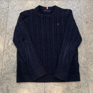 Kabelstickat hilfiger-tröja - Hej jag säljer nu min riktigt feta kabelstickad tröja från Tommy hilfiger som passar perfekt till vintern. Storleken är 164, men passar mig också som är 172cm. Skulle säga att den passar dig som är mellan 167-175cm. Priset är inte hugget i sten!!!