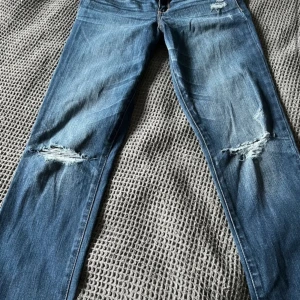 Abercrombie & Fitch bootcut jeans - Säljer ett par snygga blå jeans från Abercrombie & Fitch i L33 W29. De har snygg slitning på knäna och bakfickorna har snygga broderade detaljer jeansen är midwaist. Jeansen passar mig som är ungefär 165cm. 💗💗💗