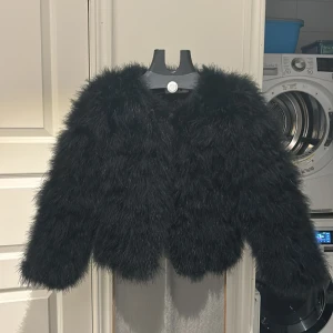 Svart pälsjacka - Säljer en fluffig svart pälsjacka Dennis Maglic. Veganska fjädrar. Ny pris 1800kr