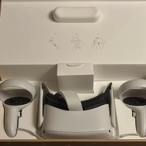 Meta Quest 2 VR-headset med resident evil 4 kod - Säljer ett Meta Quest 2 VR-headset med tillhörande handkontroller. Perfekt för en uppslukande spelupplevelse. Headsetet är vitt och har en justerbar rem för bekväm passform. Kommer i originalförpackning.