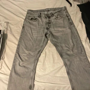 Grå jeans från Zara - Säljer ett par grå jeans från Zara. De har en klassisk femficksdesign och en knappgylf. Perfekta för en avslappnad stil.