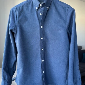 East West oxfordskjorta blå skjorta, storlek S - Blå oxfordskjorta från East West. Slim fit, storlek S. 100% bomull. Mycket bra skick. Button down. Jag säljer många skjortor i samma storlek, kolla gärna på mina övriga annonser för att skapa ett paket. Axelbredd: 43 cm Längd: 71 cm