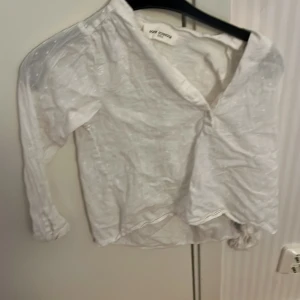 Vit blus från Sofie Schnoor - Säljer en söt vit blus från Sofie Schnoor med trekvartsärm och v-ringning. Blusen har ett diskret mönster och är perfekt för en stilren look.