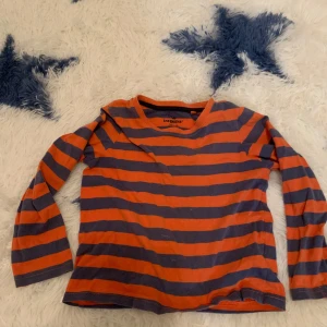 Randig tröja från Lupilu - Säljer en randig tröja från Lupilu i orange och grått. Tröjan har långa ärmar och en rund halsringning. Perfekt för en färgglad och bekväm stil. 🧡