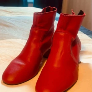 Röda boots med dragkedja - Snygga röda boots från MNG i skinn med dragkedja baktill. Perfekta för att ge en färgklick till din outfit. De har en stilren design med rund tå och är tillverkade i ett mjukt material för extra komfort.