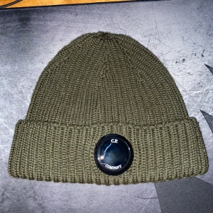 Olivgrön ribbad mössa från C.P. Company - C.P. Company mössa i väldigt bra skick. Nästan aldrig använd.