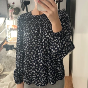 Mörkblå blus med blommor - Jag säljer en super fin mörkblå blus med vita blommor, den kommer från Kappahl och är i storlek Xs, jag säljer den för 100kr😊