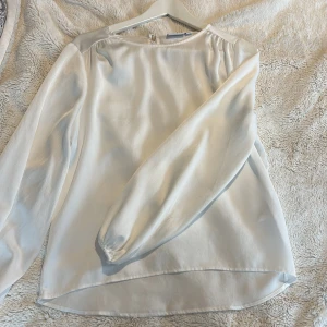 Vit blus - En oanvänd fin vit blus från vila. Storlek 34. Jätte fin och skön att ha i sommar. ”Utsvängd” ner till med band i armarna. 
