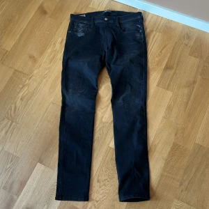 Svarta jeans från Replay - Snygga svarta jeans från Replay i modellen Anbass. De har en slim fit passform och är perfekta för en stilren look. Klassisk femficksdesign med knapp och dragkedja i gylfen.