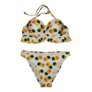 Vit bikini med ananasmönster - Snygg vit bikini med färgglatt ananasmönster. Överdelen har knytband runt nacken för justerbar passform. Volangdetaljer ger en söt touch. Perfekt för sommarens stranddagar! Helt oanvänd och i toppskick. 