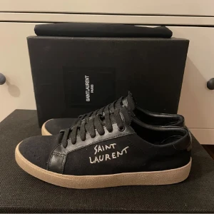 Saint Laurent skor  - Saint Laurent court classic sneakers i färgen svart och är i storlek 41 men passar 42 dom är i väldigt fint skick. Tar byten. Bara skriv om det är något som ni undrar över 🍾dom är lite sönder där fram men något som absolut går att laga.