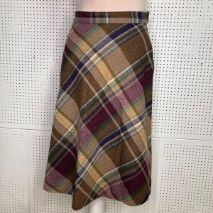 Rutig kjol med dragkedja och knapp 70s - Snygg rutig kjol i jordnära färger som brunt, grönt och lila. Kjolen har en dragkedja och knapp i midjan för enkel på- och avtagning. Perfekt för en stilren look.                                                      Waist Width: 28.0 cm. Hip Width: 48.0 cm. Bottom Hem Width: 71.5 cm. Outseam Length: 60.0 cm. Skirt Length: 60.0 cm.  