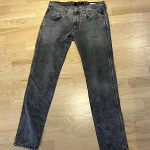 Replay anbass jeans - Snygga grå jeans med en klassisk femficksdesign och knappgylf. De har en straight passform och är perfekta för en avslappnad stil. Materialet är slitstarkt och ger en cool look. W32 L32,kontakta oss vid frågor🤝